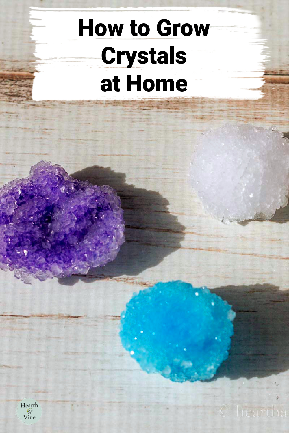 Three homemade borax crystals. One purple, one white and one blue.