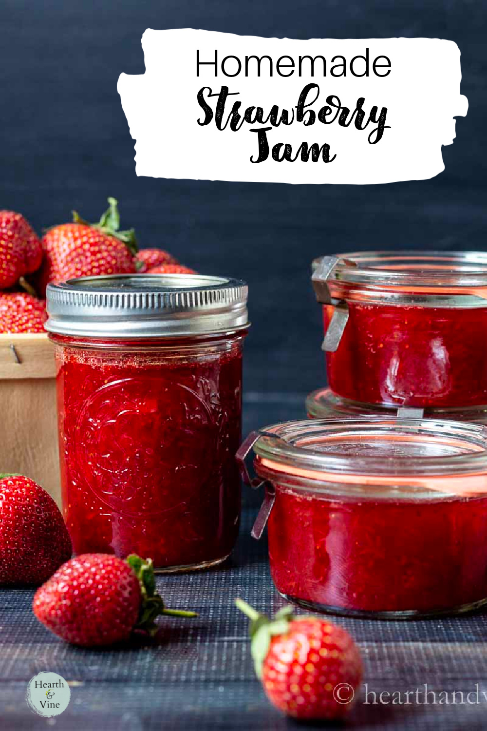 Jars of strawberry jam and fresh strawberries scattered around them.