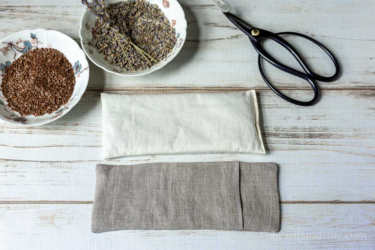 Bowls of flaxseed and dried lavender, a pair of scissors, a muslin filled pillow and a linen pillow cover.