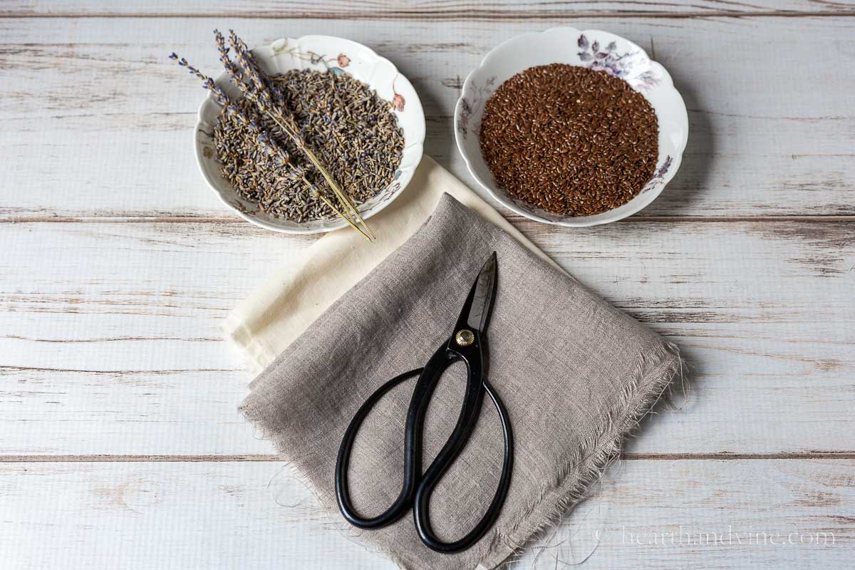 Bowls of lavender and flaxseed, scissors, linen and muslin fabric.