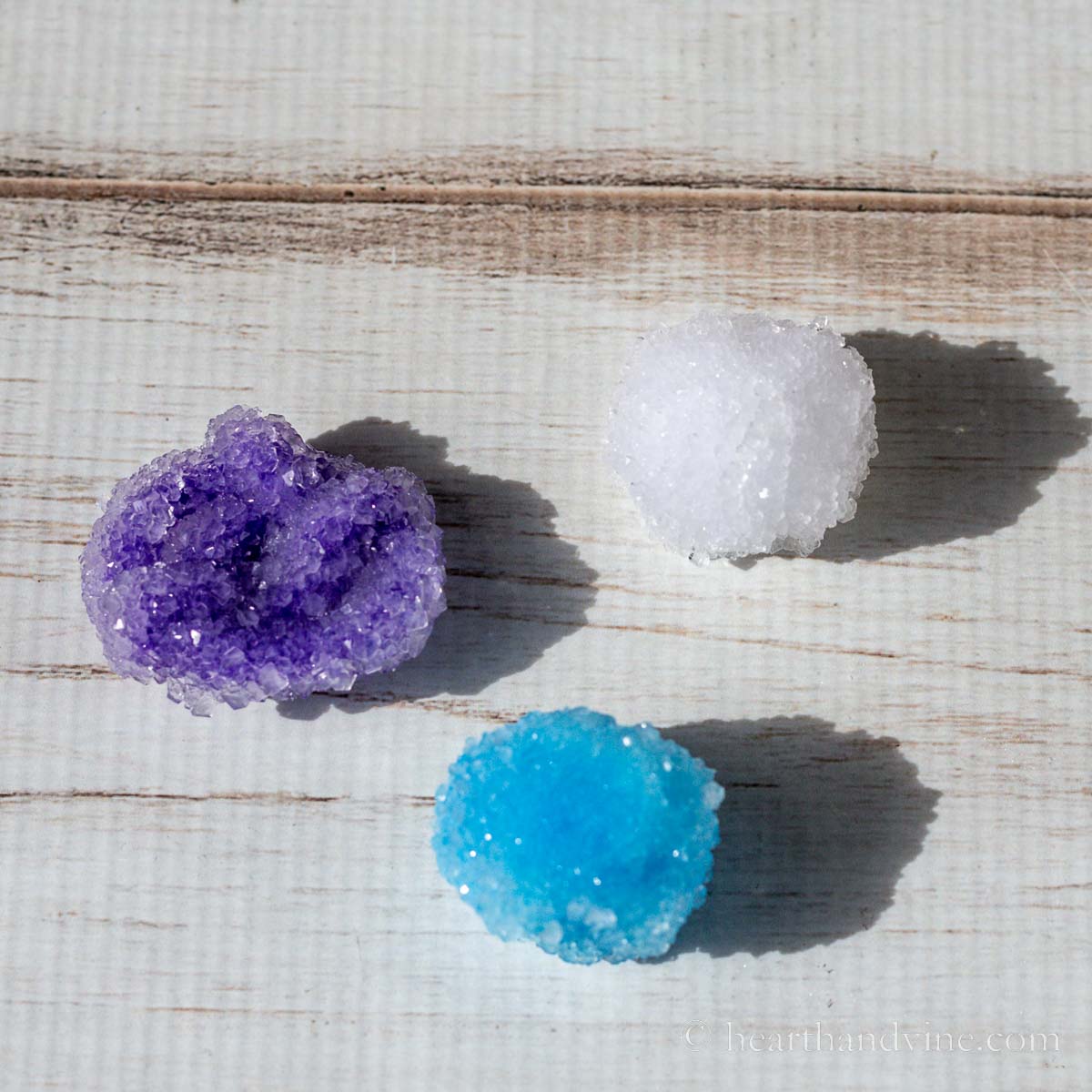 Three crystals made from Borax, pipe cleaners and craft puff balls.