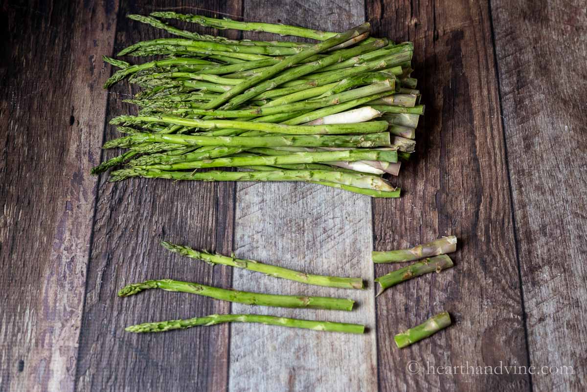 Bunches of asparagus and a few spears with the bottoms broken off.