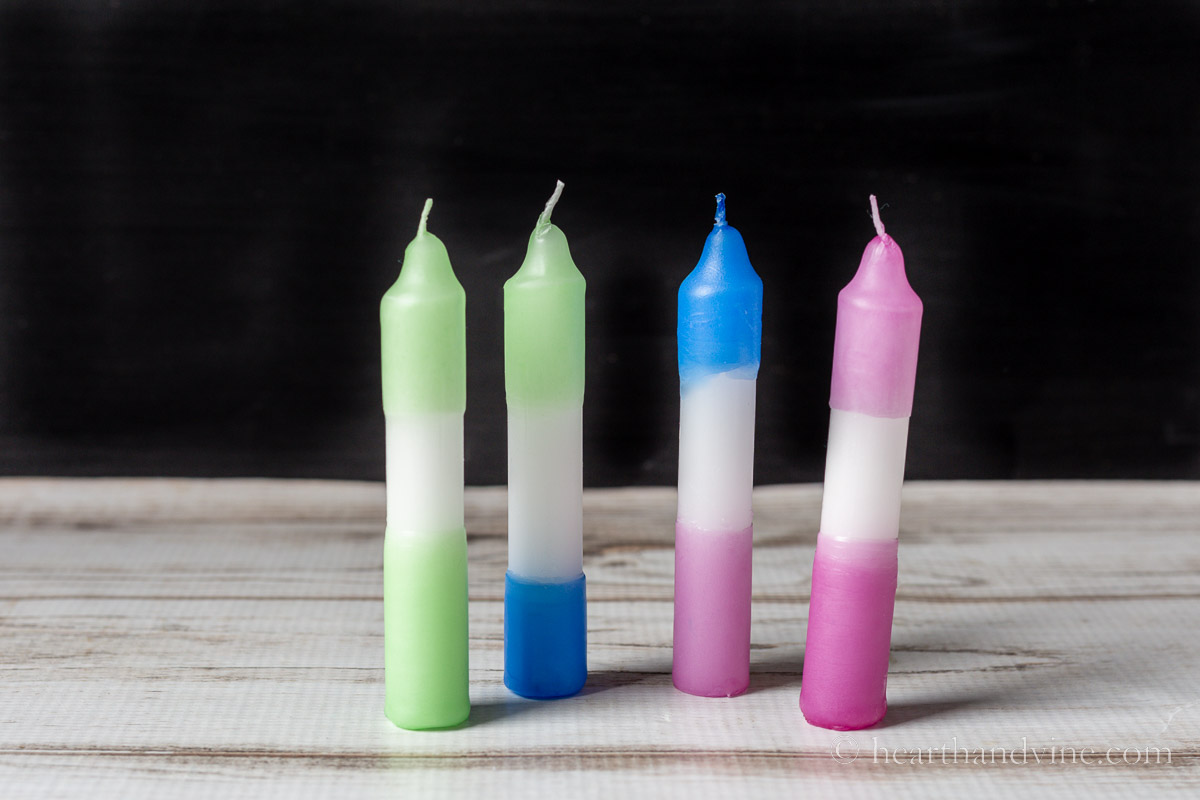 Four dip-dyed-candles in colors of blue green and pink.