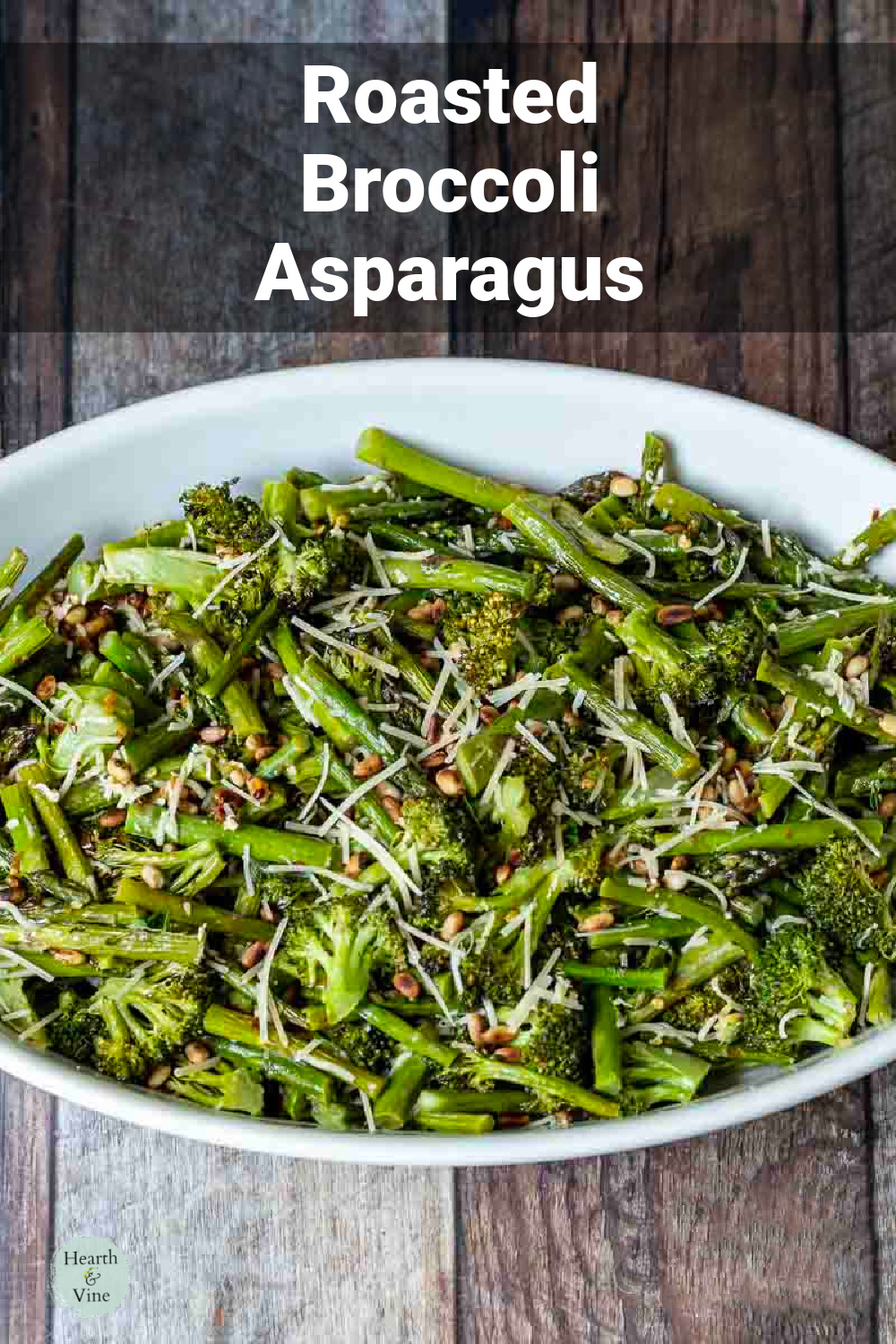 Roasted broccoli and asparagus in a baking dish with parmesan and toasted pine nuts.