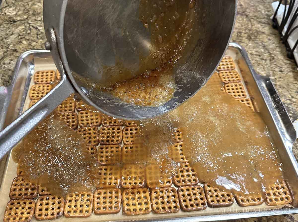 Hot caramel mixture poured onto pan with pretzels.