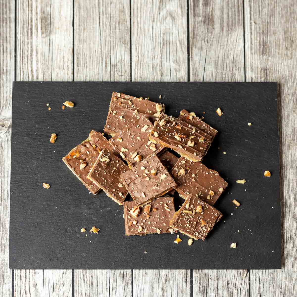 Black slate with pretzel toffee cut up in pieces.