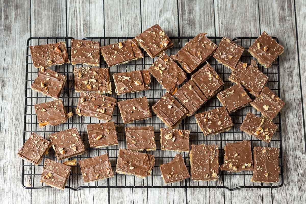 Cut up pieces of chocolate pretzel toffee on a cooling rack.