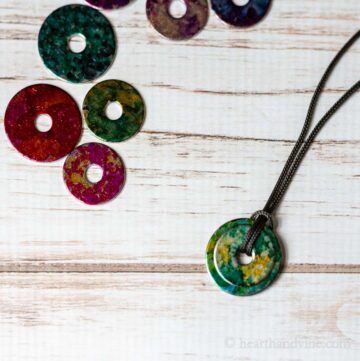 Alcohol in washer necklace next to a few decorated washers with alcohol inks.
