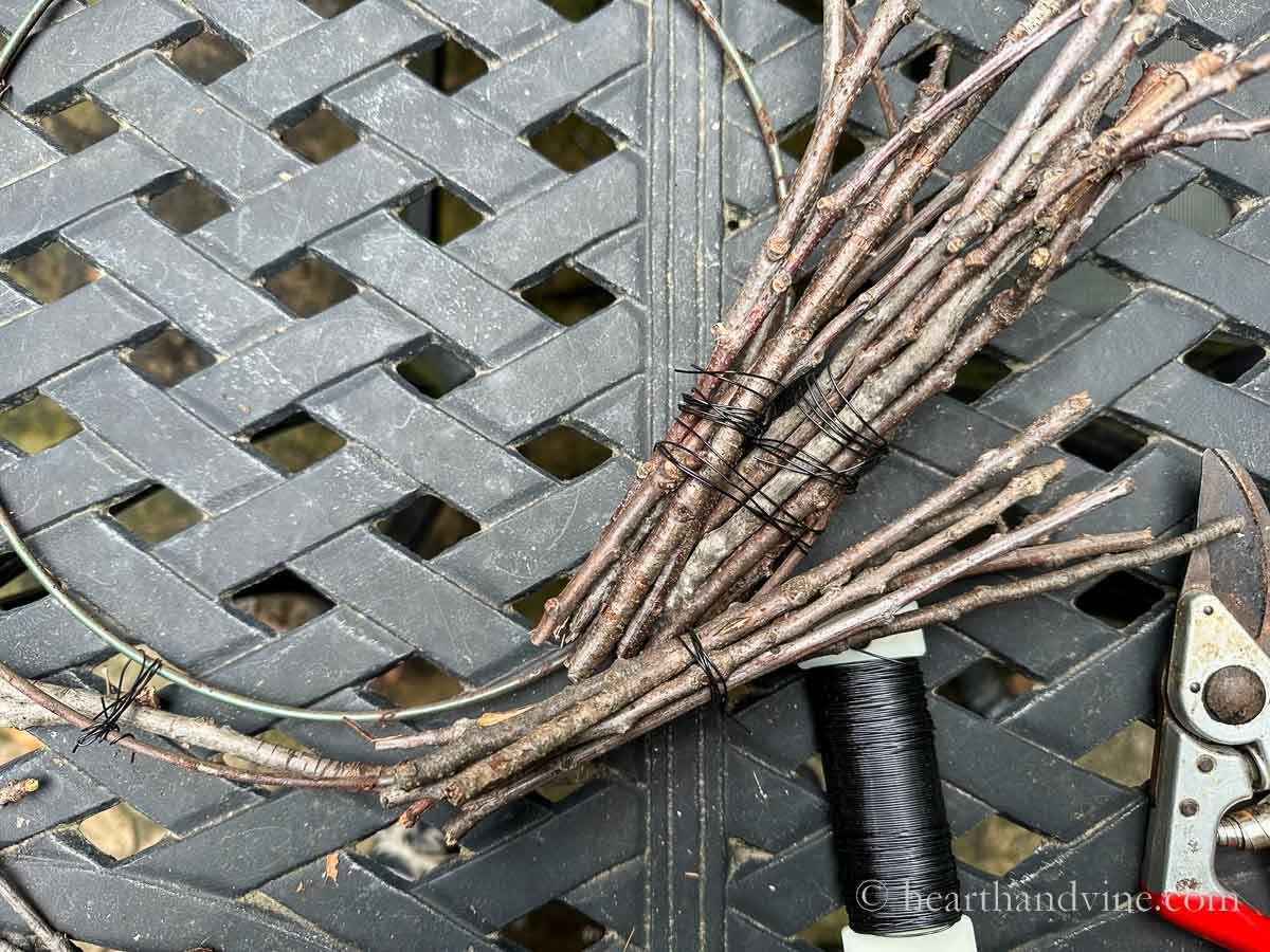 Bundles of twigs being wrapped onto a wire wreath frame.