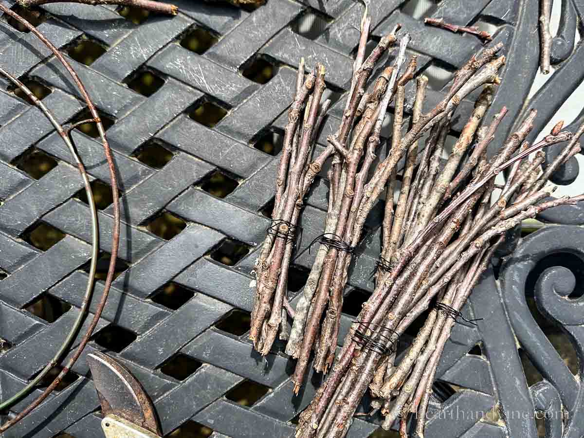 Several twig bundles with black floral wire.