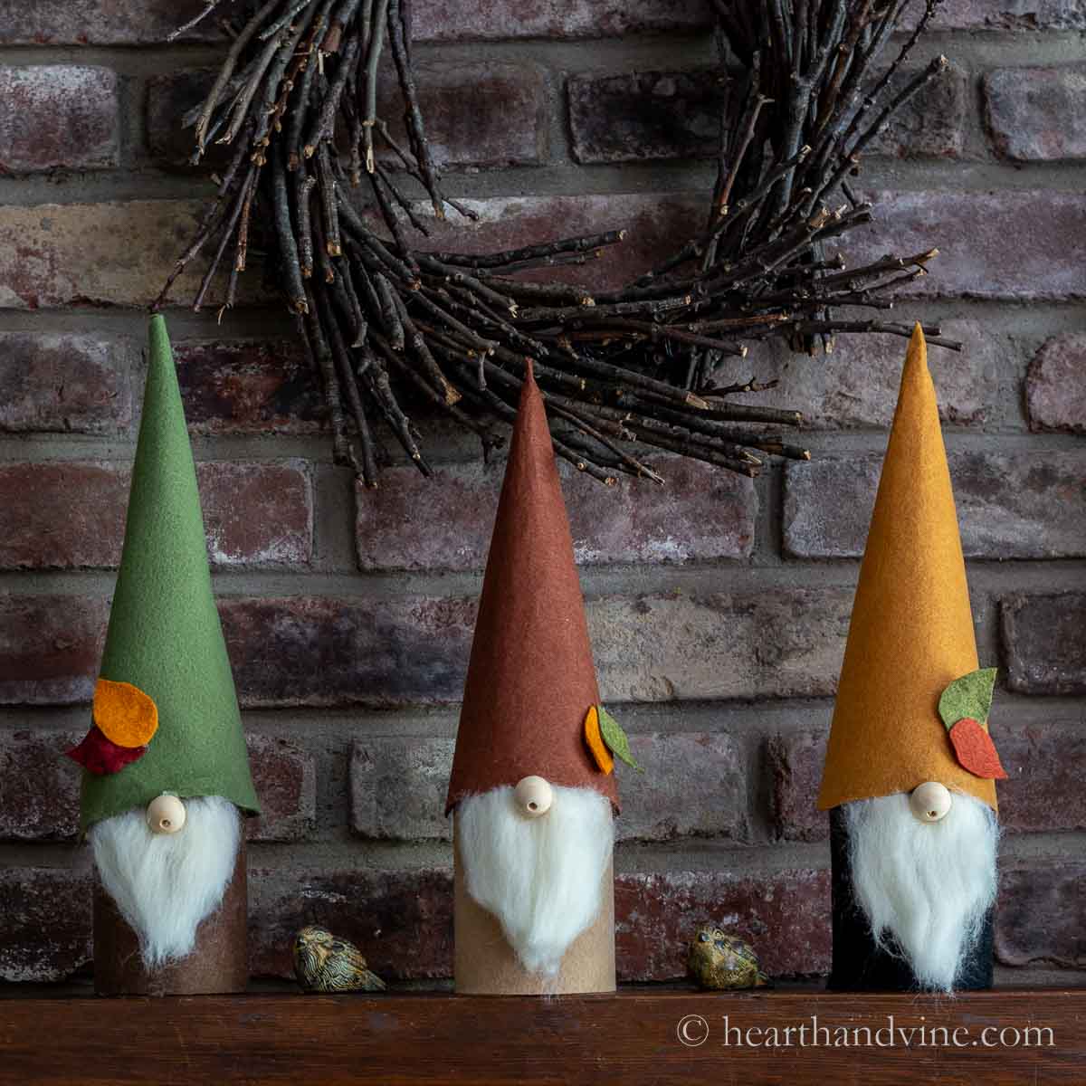 Three fall themed gnomes on a mantel.