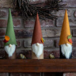 Three woodland themed fall gnomes on a mantel.