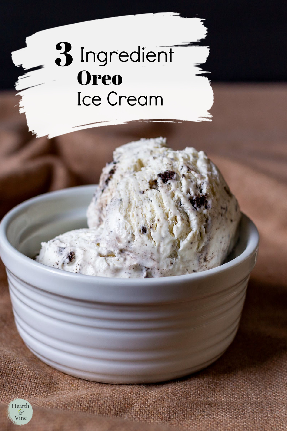 Two scoops of Oreo ice cream in a white bowl.