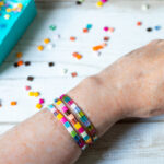 Three bracelets on a wrist with tila beads.