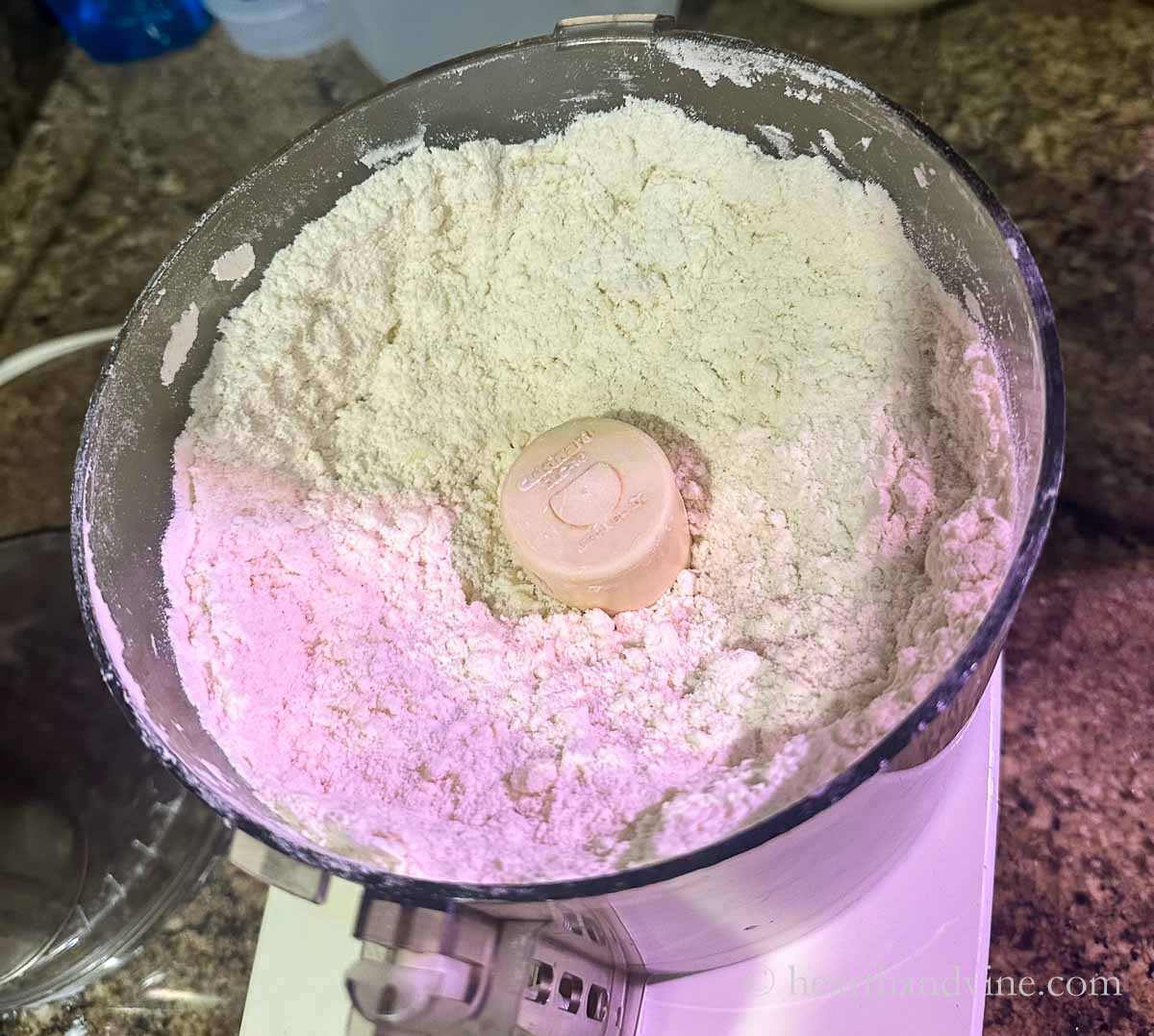 Flour mixture in a food processor with cold butter cubes mixed in.