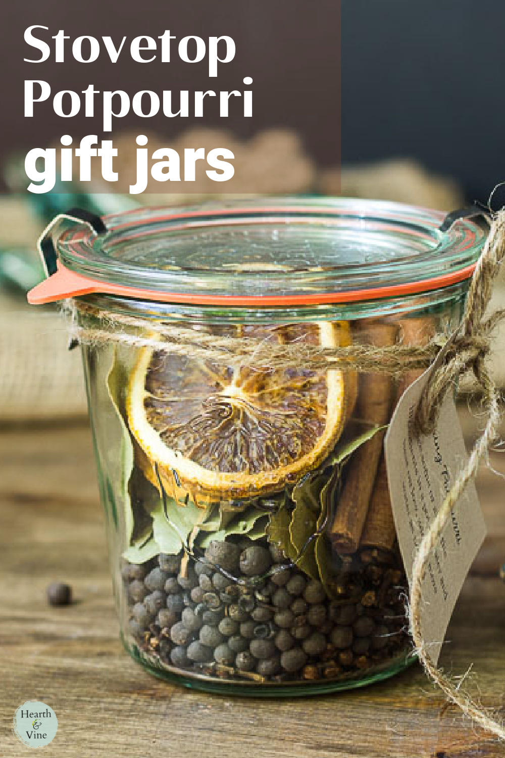 Glass Weck jar with instruction tag filled with dried orange slices, bay leaves, cinnamon sticks, cloves and whole allspice for a gift of stovetop potpourri.