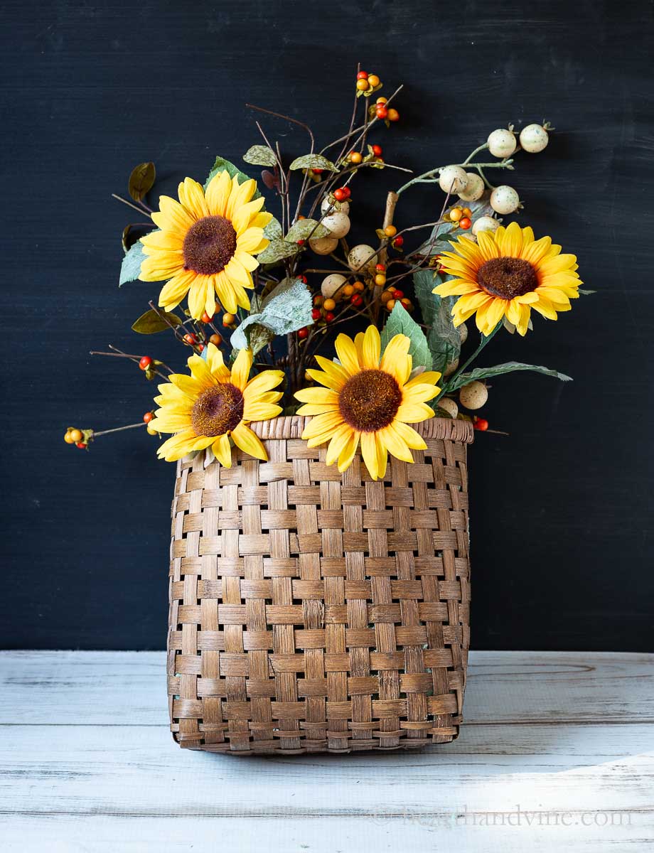 Faux fall berries and sunflowers in a basket.