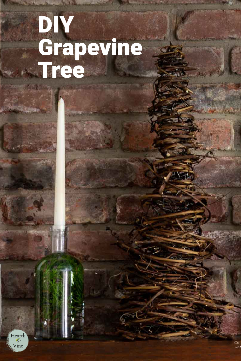 Grapevine cone shaped Christmas tree on a mantel next to a bottle with water and greens and a white taper candle in the top.