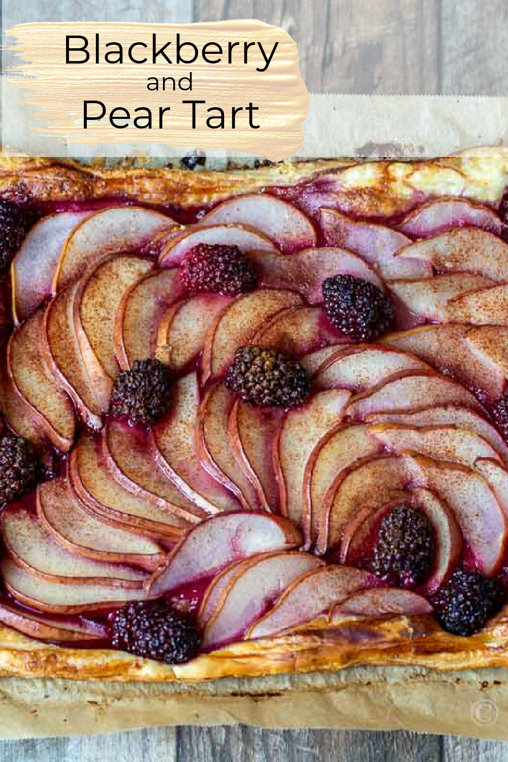 Pear tart with blackberries on puff pastry base.