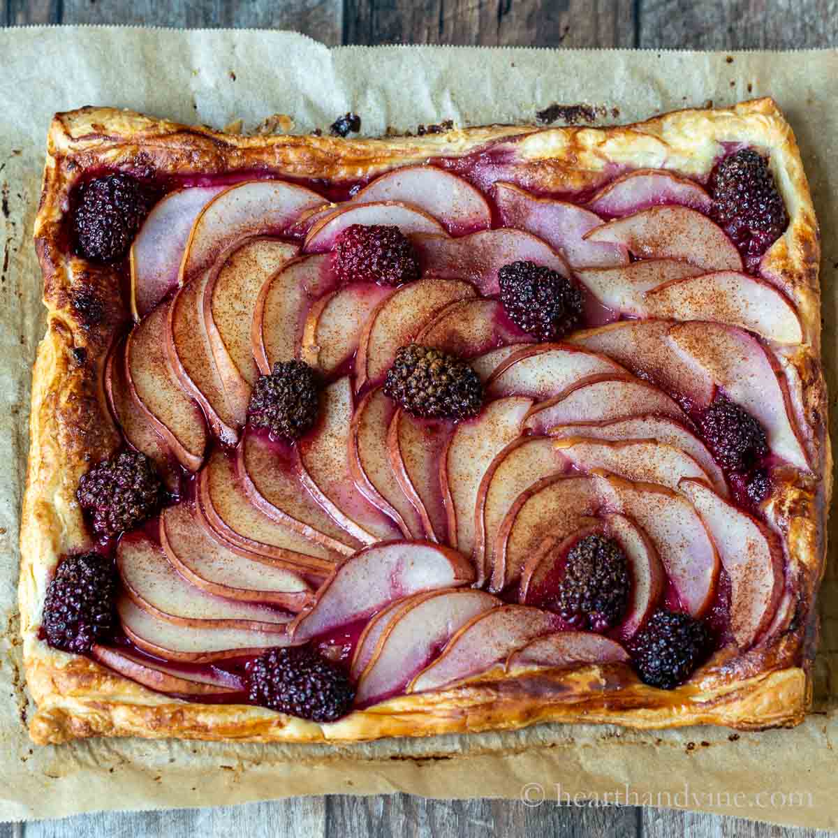 Blackberry and pear tart on parchment paper.