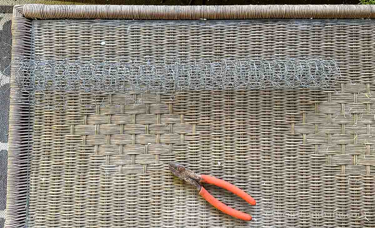 Chicken wire on a table with wire cutters.