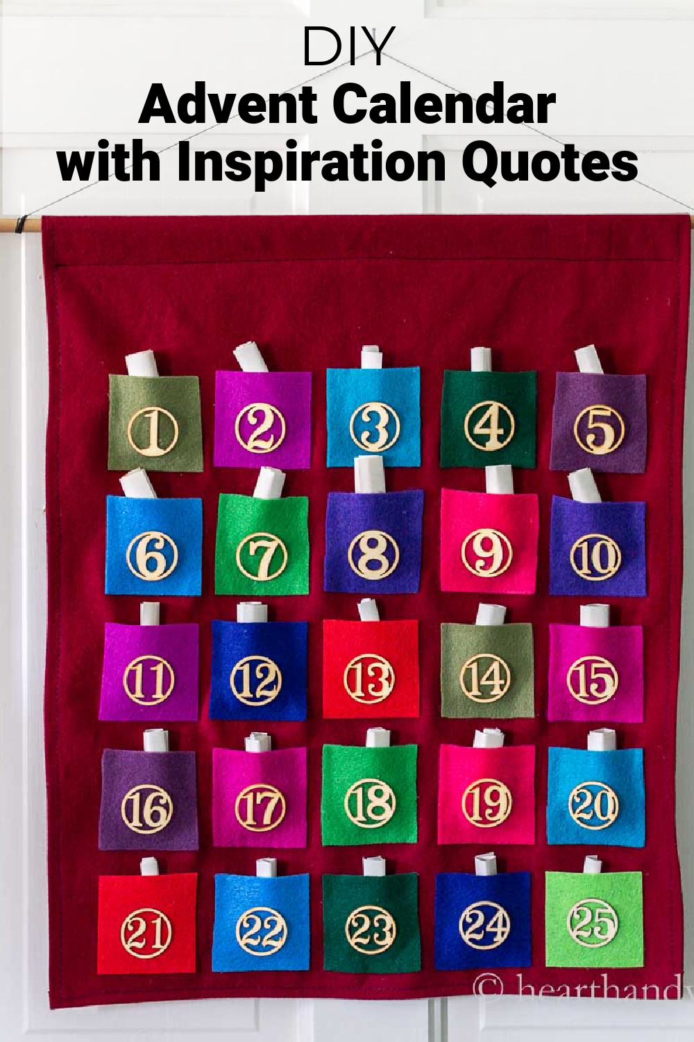 A felt advent calendar with red backing and multi-colored felt pockets holding paper scrolls.