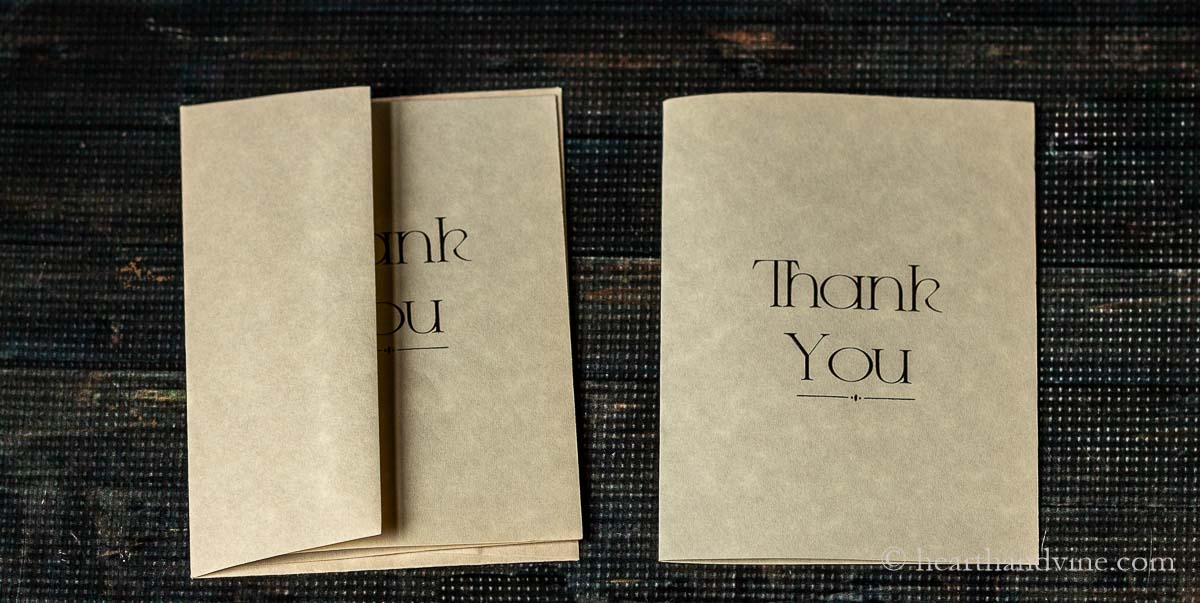 Black ink thank you card with envelope on parchment paper.