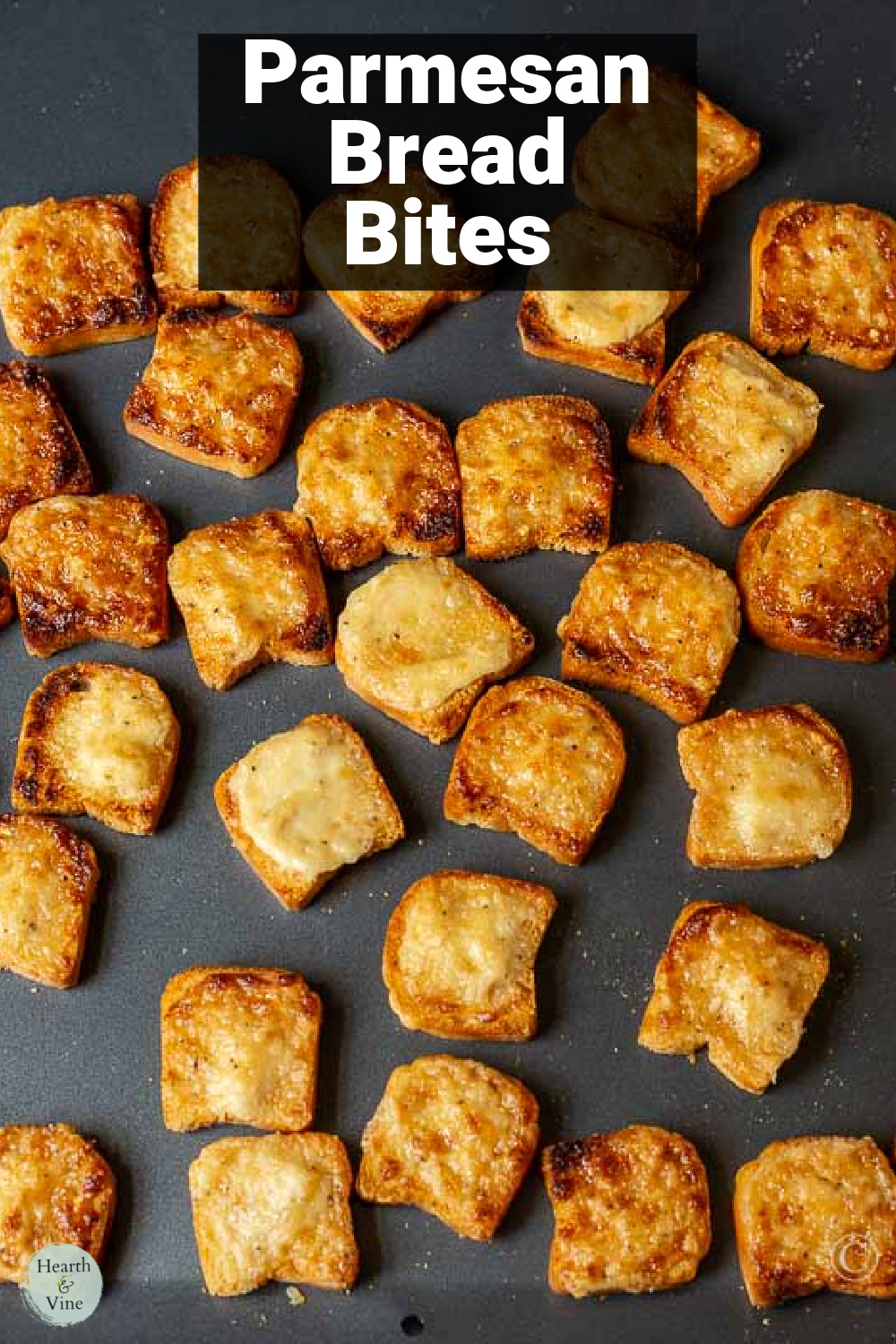 Broiled Parmesan bread bites on a baking sheet.