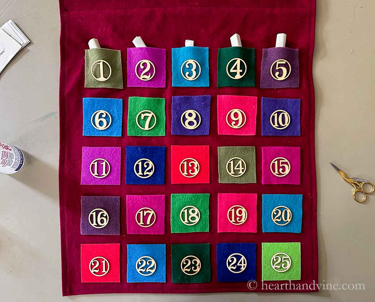 Finished felt advent calendar with some of the quote scrolls placed in the felt pockets.
