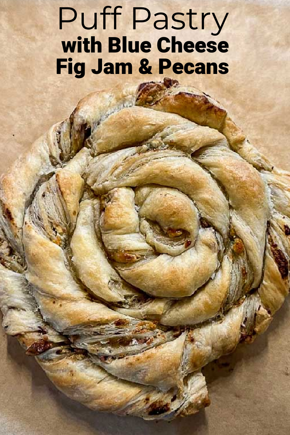Blue cheese puff pastry in a spiral shape on parchement.