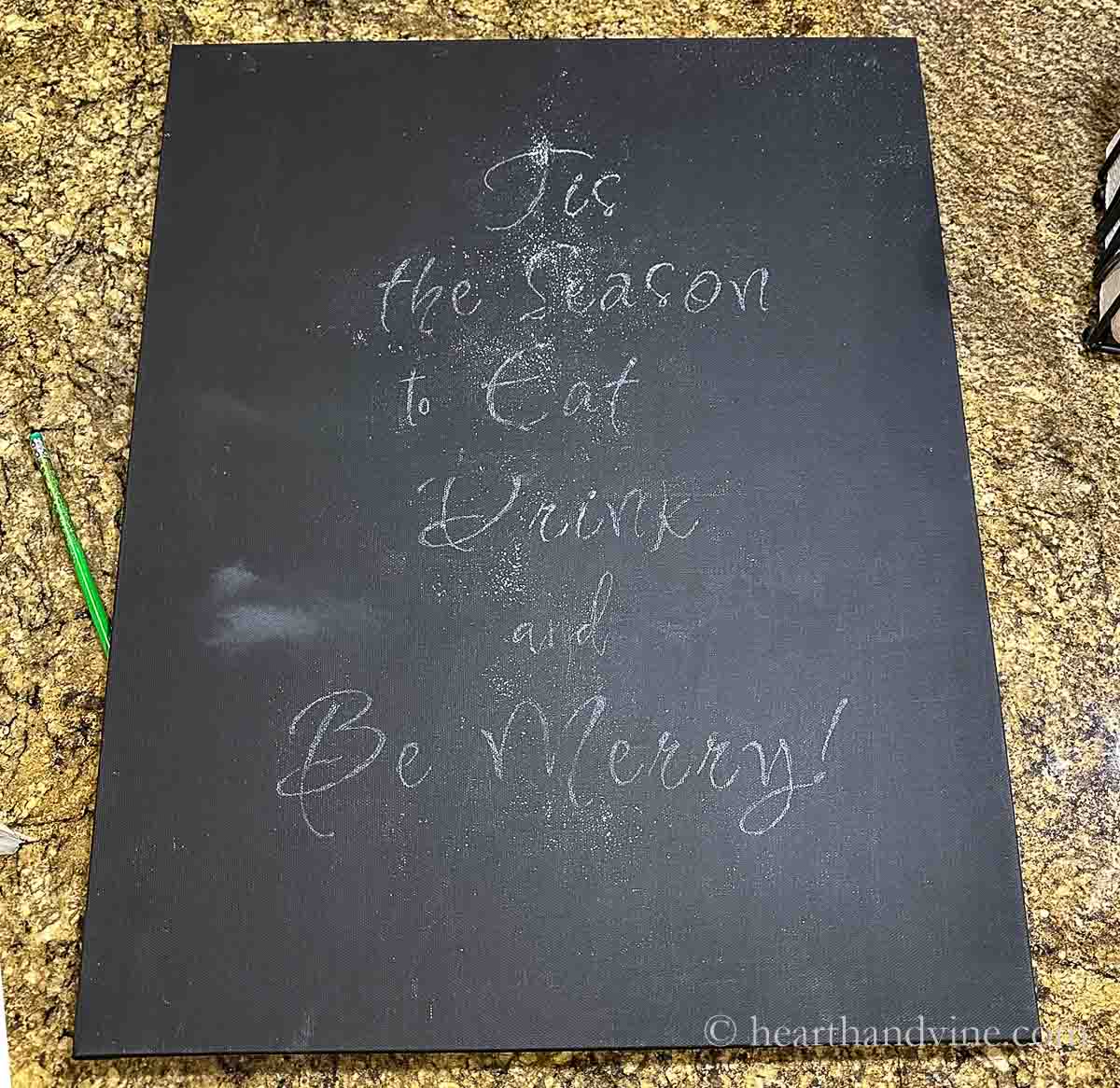 The painted canvas with the saying transferred in white chalk.