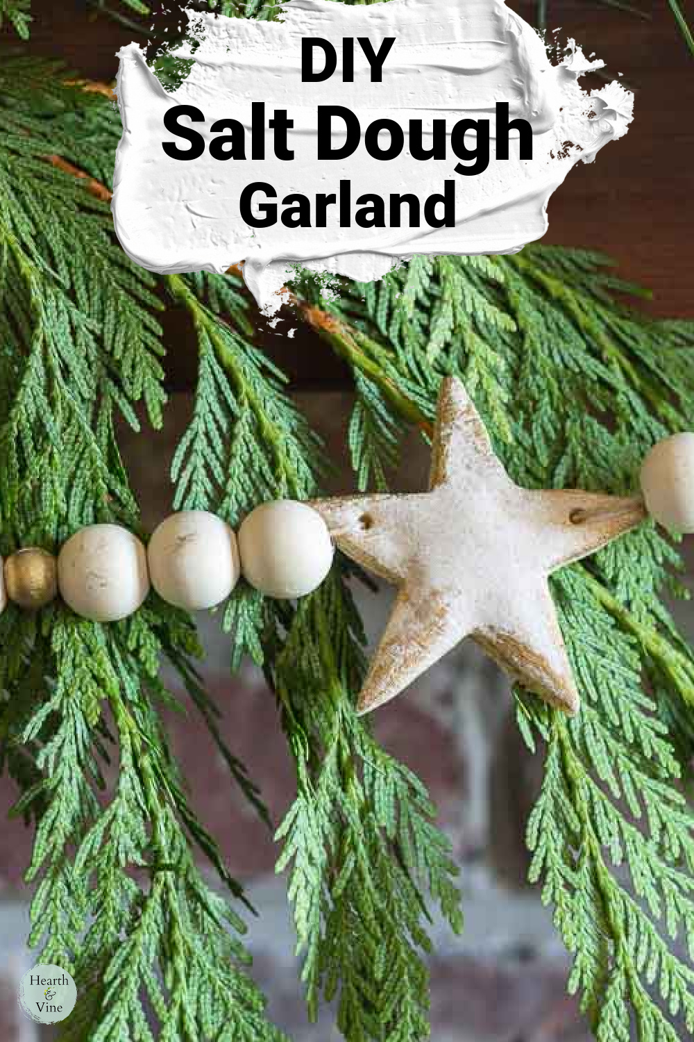 Star salt dough garland with wooden beads on fresh cedar.