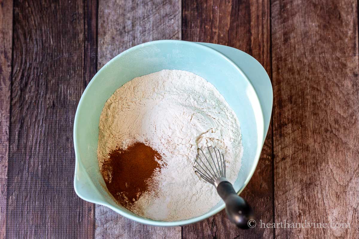 Flour, baking soda, baking powder, salt and ground cinnamon in a mixing bowl with a wire whisk.