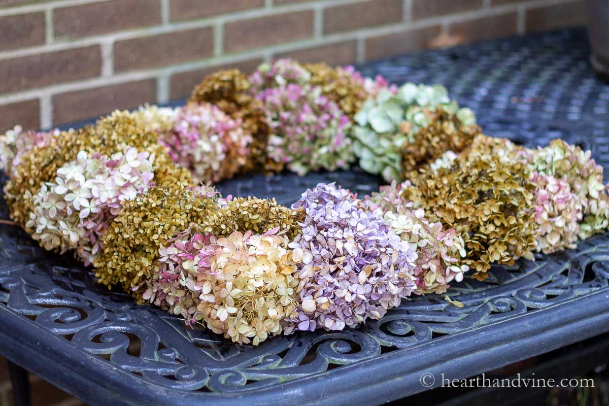 Dried hydrangea wreath laying on a table.
