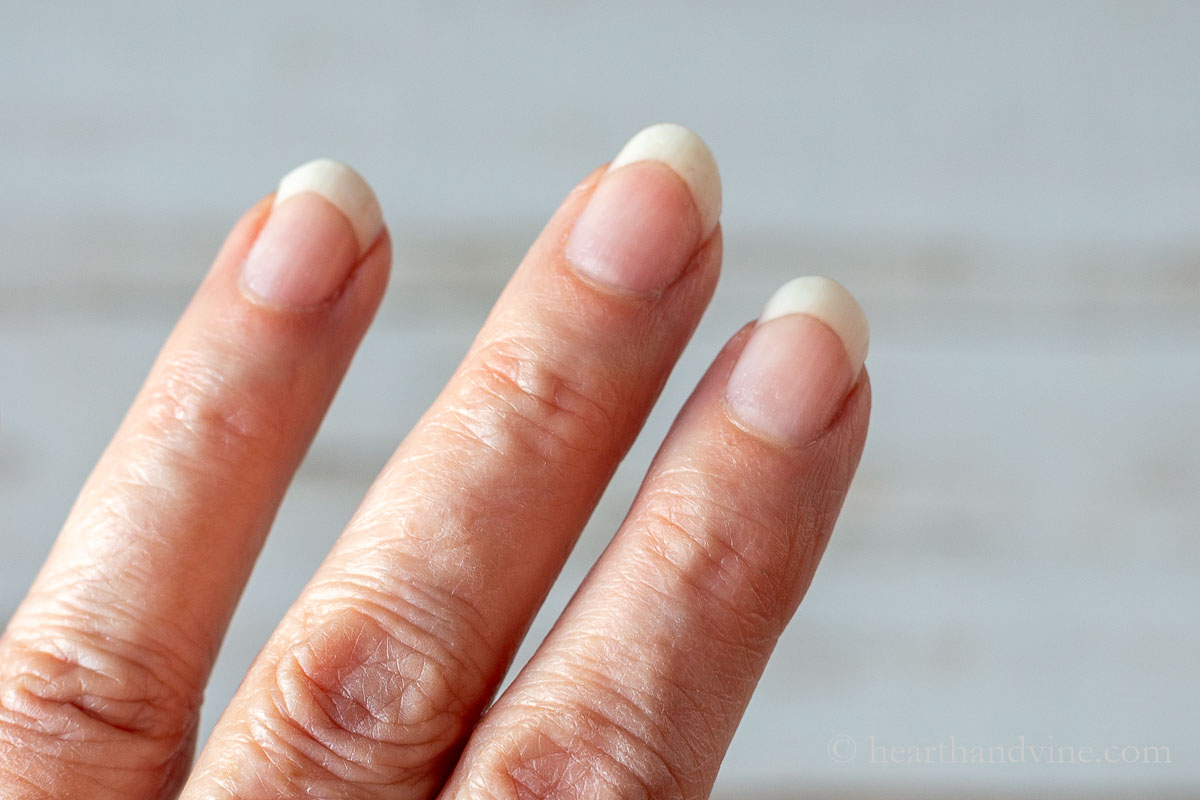 Three fingers showing improved cuticles after using cuticle cream.