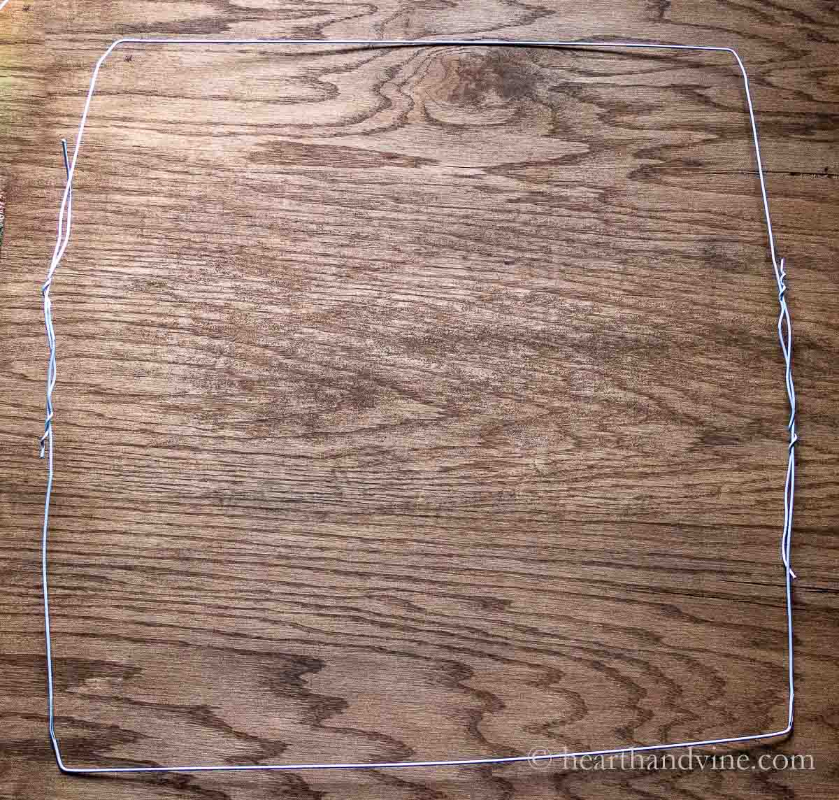 White wire hangers made into a large square.