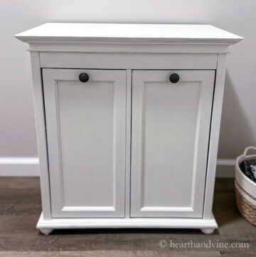 Small cabinet painted white in bathroom.