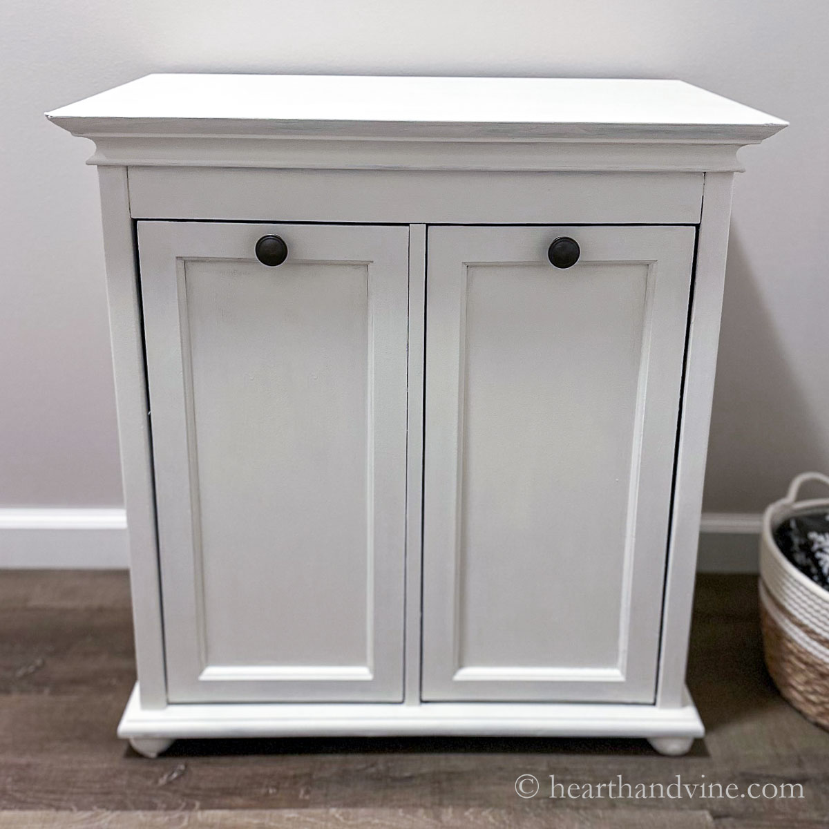 Small white painted cabinet in a bathroom.