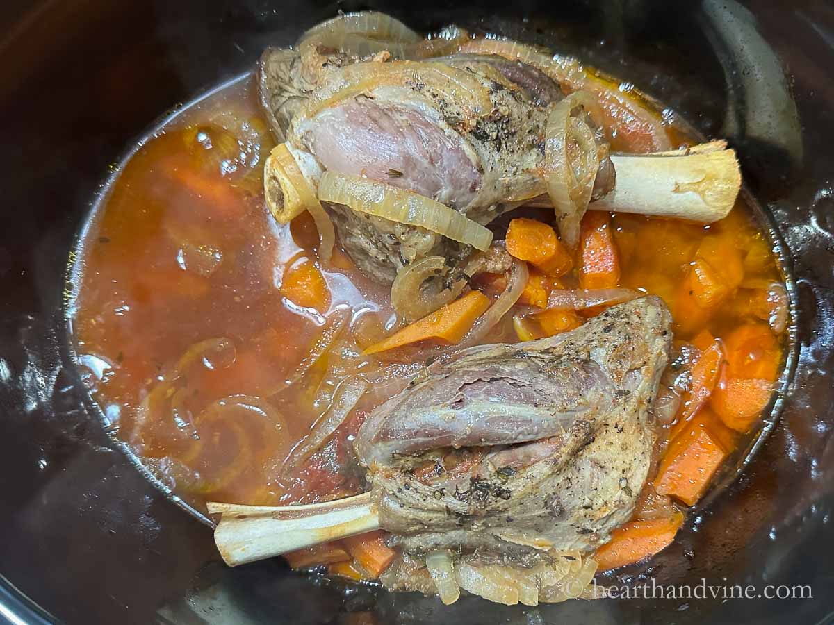 Slow cooked lamb shanks with carrots and onions.