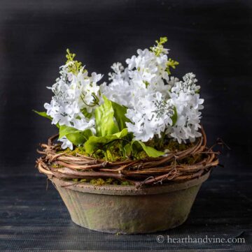 White artificial flower arrangement in a terracotta pot.