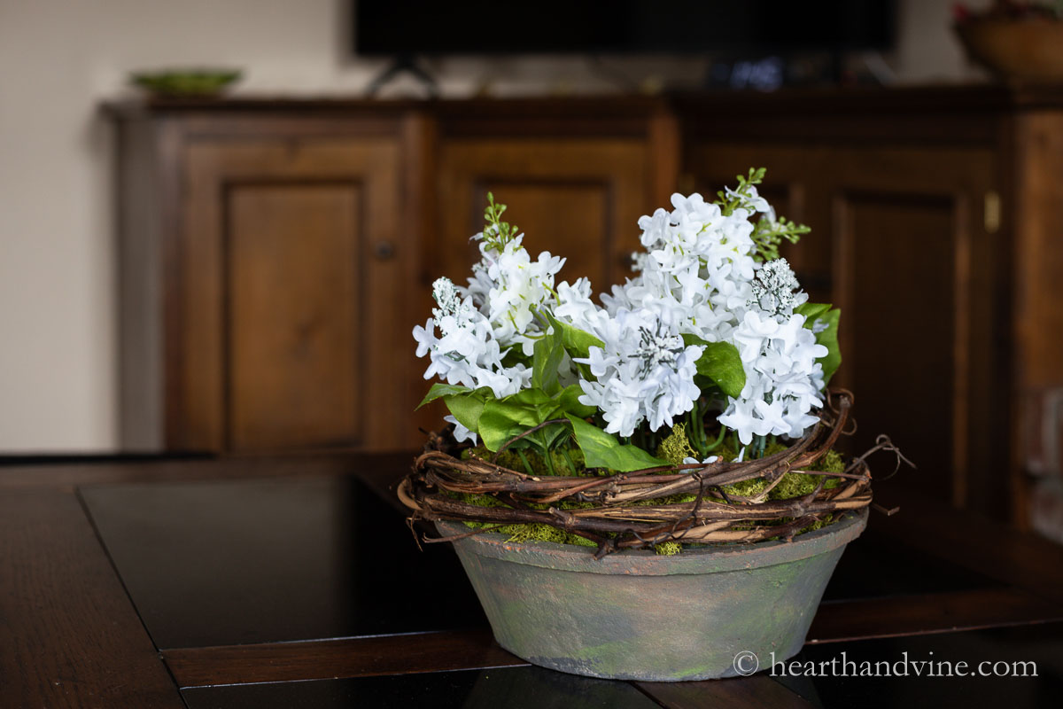 A white artificial flower arrangement on a living room table.