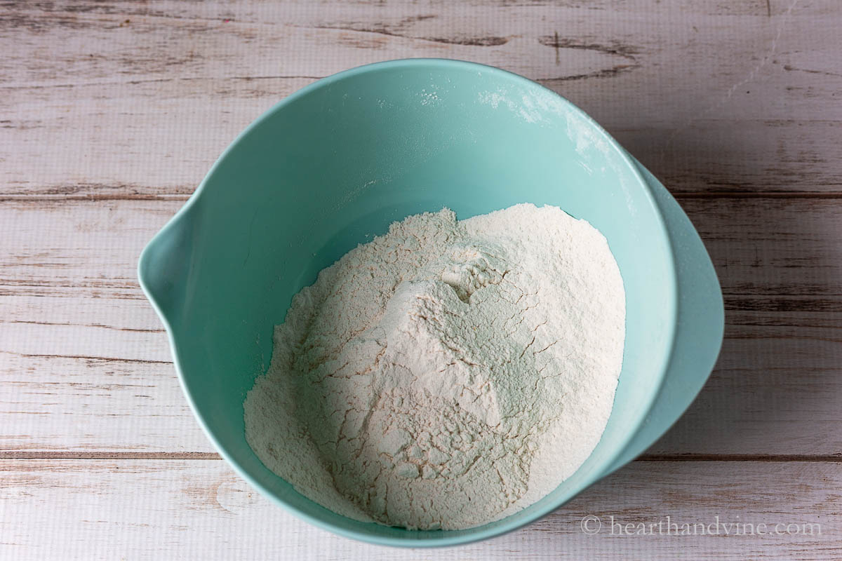 Large mixing bowl with flour, baking powder, baking soda and salt.