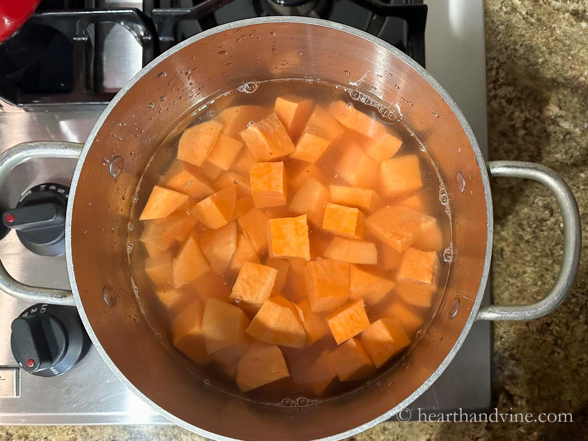 Cubed sweet potatoes in a pot of water on the stove.