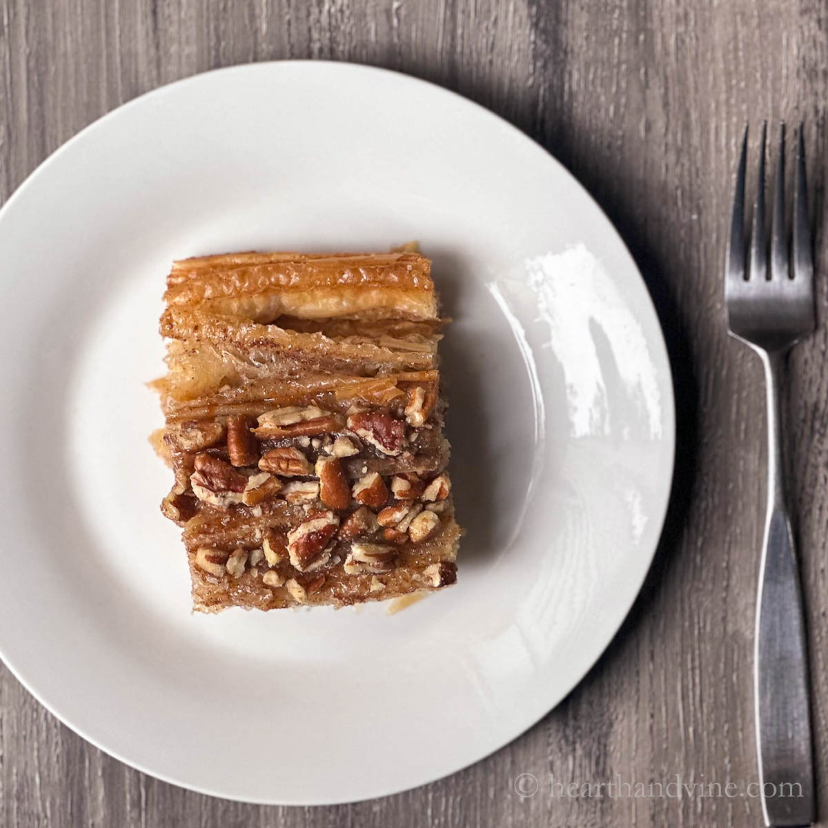 Piece of cinnamon pecan crinkle cake on a white plate.