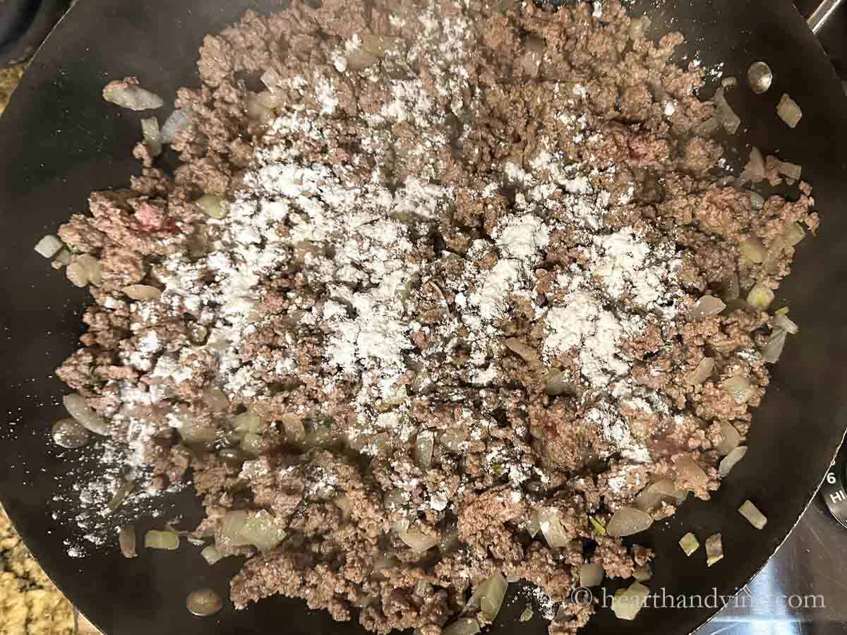 Flour sprinkled over onion and ground beef mixture.