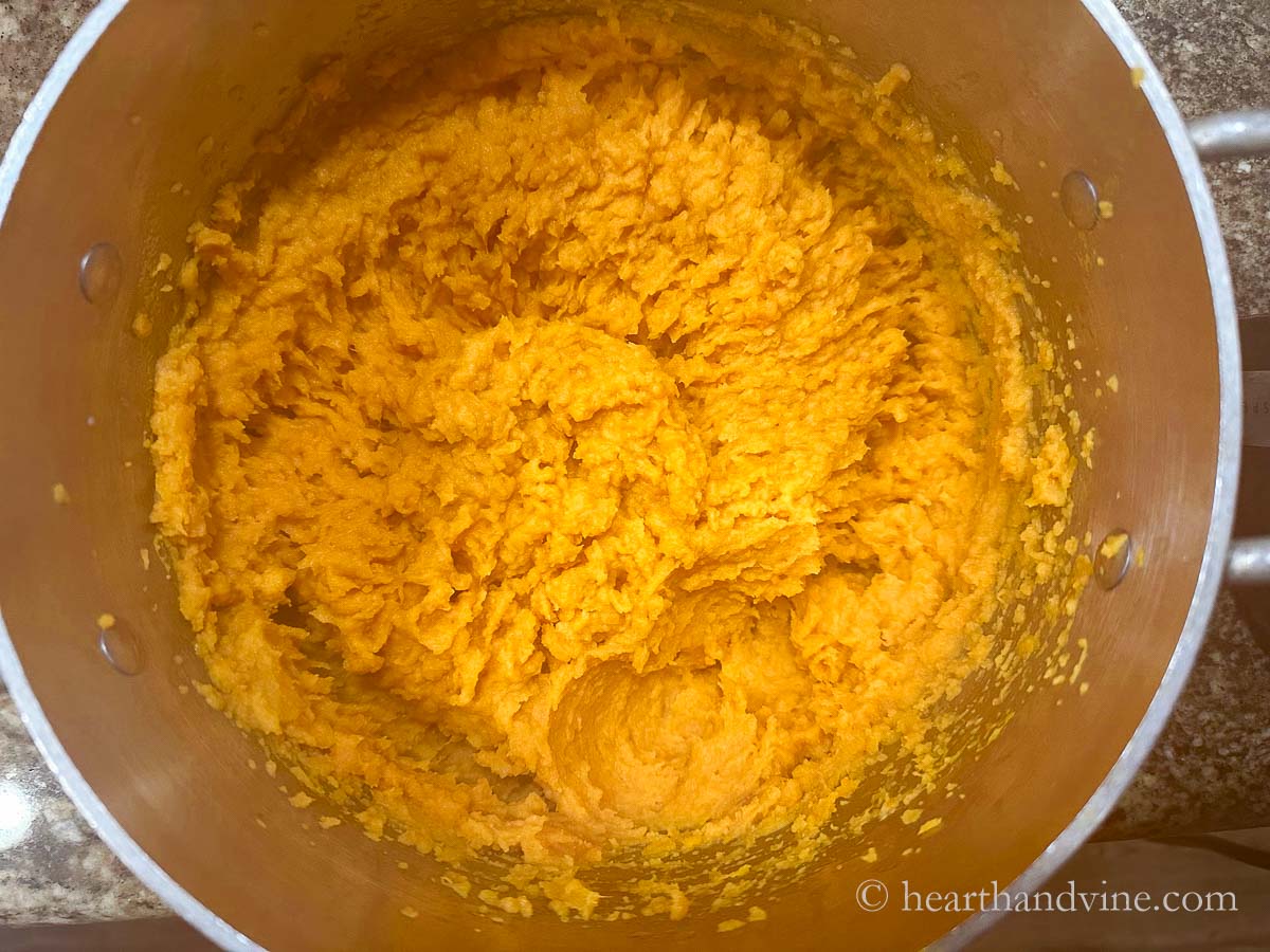 Sweet potatoes mashed in a pot.