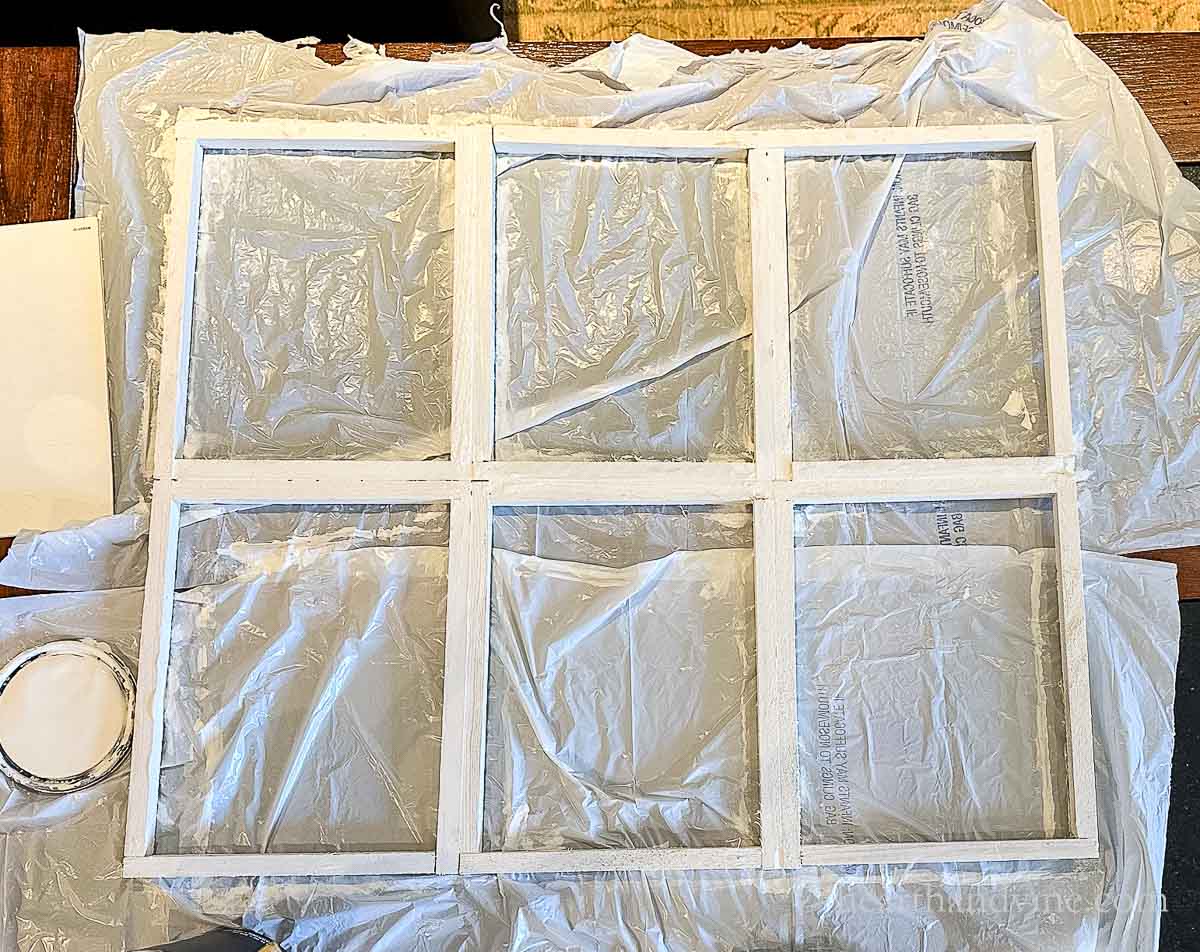 Wooden window frame painted with white chalk paint.