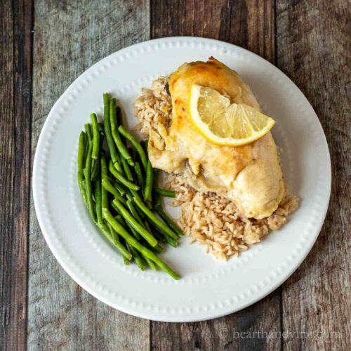 Lemon chicken breast over rice and a side of green beans.