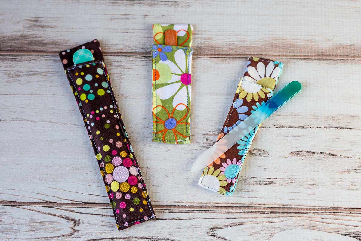 Three fabric nail file holders in colorful patterns and different sizes files.