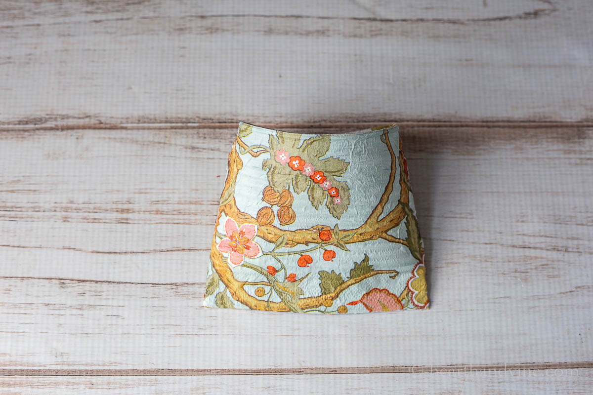 The smashed can basket covered with a pretty printed paper napkin.
